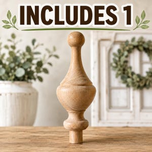 May include: A light brown wooden finial with a smooth, turned silhouette featuring a spherical top, a bulbous middle section, and a cylindrical base. The text INCLUDES 1 is displayed at the top of the image in bold, dark brown capital letters.