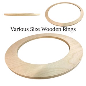 May include: Various Size Wooden Rings. A set of three unfinished wooden rings, ideal for crafting projects. The rings are made of natural wood and have a smooth, polished finish.
