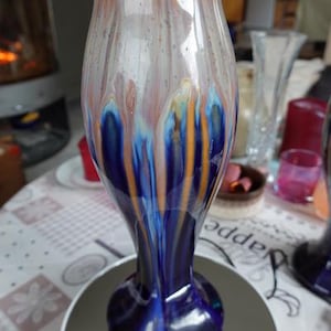 Peut inclure: Un vase en verre bleu et or avec un design en spirale unique. Le vase a une large ouverture et une base étroite.