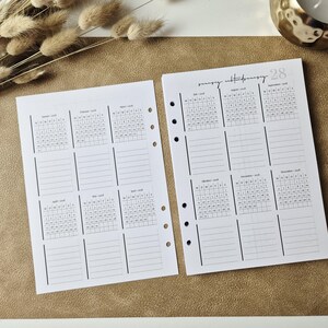 May include: Two white planner pages with black ink, featuring a 2018 calendar layout. Each page contains six monthly grids with corresponding lined note sections. The pages have pre-punched holes along the inner edges for binder insertion.