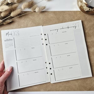 May include: An open planner with white pages featuring black text and lines. The left page shows a monthly calendar for March, a weekly schedule, and a list of checkboxes. The right page displays daily sections for Thursday through Sunday.