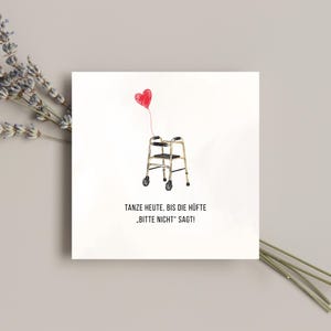 Può includere: Biglietto quadrato con un'illustrazione umoristica. Un palloncino rosso a forma di cuore è attaccato a un deambulatore. Il biglietto presenta il testo tedesco "TANZE HEUTE, BIS DIE HÜFTE 'BITTE NICHT' SAGT!"