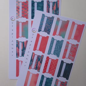 Può includere: Due fogli di adesivi per planner con una varietà di disegni colorati. Gli adesivi presentano un mix di motivi, tra cui floreali, geometrici e astratti, nelle tonalità corallo, verde acqua e blu. Il testo "by the planner" è stampato verticalmente sul lato sinistro.