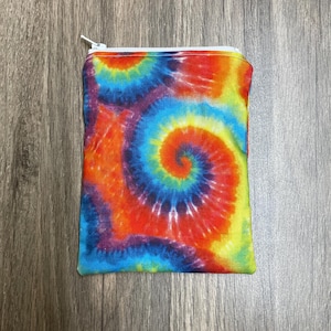 May include: A small zippered pouch with a tie-dye pattern in shades of blue, red, yellow, and purple.