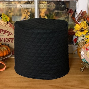 May include: Black quilted fabric cover for a kitchen appliance. The cover is quilted with a diamond pattern.