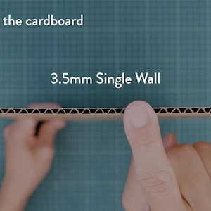 May include: A close-up of a piece of corrugated cardboard, held between two hands. The text "Thickness of the cardboard" and "3.5mm Single Wall" are visible. The cardboard has a brown, ridged interior.