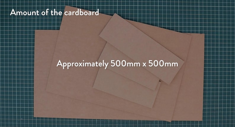 May include: Several pieces of brown cardboard are arranged on a green grid surface. The text "Amount of the cardboard" and "Approximately 500mm x 500mm" are visible in white text.