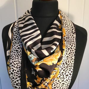 Opvallende zwart-gouden zijden sjaal, met gepersonaliseerde geschenkverpakking. Thema dierenprint. Geweldig cadeau voor een betaalbare prijs!!