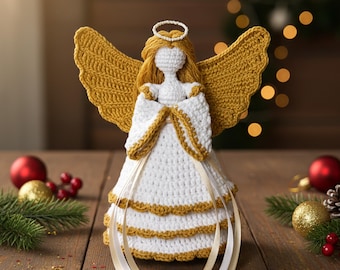 May include: A handcrafted crochet angel figurine with white and gold accents. The angel has golden wings, a halo, and a white dress with gold trim. Decorative ribbons hang from the dress. The angel is a Christmas or holiday decoration.