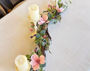 Centro de mesa con flores silvestres, eucalipto y magnolia, con portavelas de madera flotante.