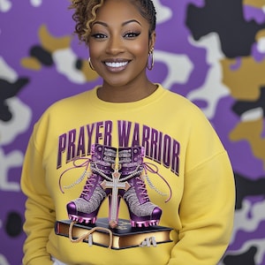 May include: Yellow sweatshirt with the text "PRAYER WARRIOR" in purple. The sweatshirt features a graphic of two purple high-heeled boots with rhinestones and a cross on a gold bible.