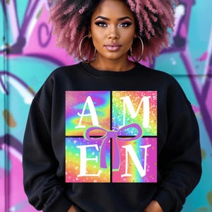 Op de afbeelding: Zwart sweatshirt met een regenboog- en glitterontwerp met de tekst "AMEN" in witte letters.