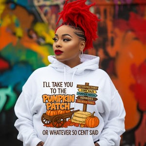 May include: White hoodie with the text "I'll Take You To The Pumpkin Patch Or Whatever 50 Cent Said." The graphic includes a wagon with pumpkins, hay bales, and a signpost with fall activities. The person in the image has red hair.