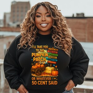 May include: Black sweatshirt with the text "I'll take you to the pumpkin patch or whatever 50 cent said." The graphic includes a wooden cart with pumpkins, a hay bale, and a signpost with fall activities.
