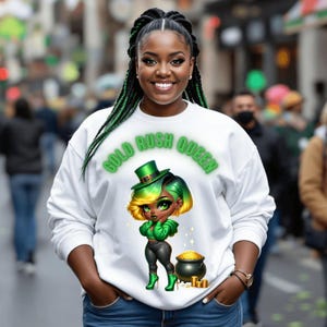 May include: White sweatshirt with a green, yellow and black cartoon illustration of a woman wearing a green hat and holding a pot of gold. The text "Gold Rush Queen" is printed in green on the shirt.