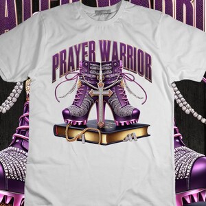 May include: White t-shirt with the text "PRAYER WARRIOR" in purple letters. Two purple high-heeled shoes with jeweled embellishments are on top of a closed book with a gold cross.