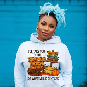 May include: A light blue hoodie with a graphic featuring pumpkins, a wagon, and a signpost pointing to a corn maze, pumpkin patch, and haunted trail. The text reads "I'LL TAKE YOU TO THE PUMPKIN PATCH OR WHATEVER 50 CENT SAID."