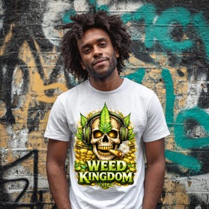May include: A light gray t-shirt featuring a skull wearing headphones and a cannabis leaf crown, smoking a cigar. The design includes gold coins and the words "WEED KINGDOM" in green and yellow.