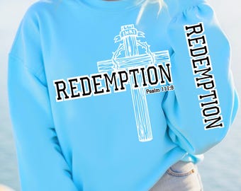 May include: A light blue sweatshirt with a white cross and the word "REDEMPTION" printed on the front. The cross has the words "INRI" on the top and "Psalm 111:9" below it. The word "REDEMPTION" is also printed on the sleeve.