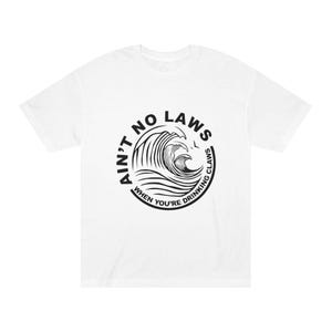 Könnte beinhalten: Weißes T-Shirt mit einer schwarzen Grafik einer Welle in einem Kreis. Der Text um die Welle lautet: "AIN'T NO LAWS WHEN YOU'RE DRINKING CLAWS."