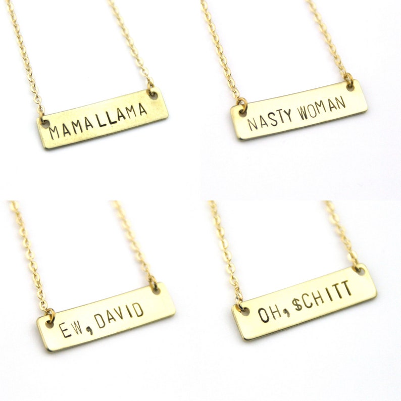 K&ouml;nnte beinhalten: Vier goldene Halsketten mit verschiedenen Spr&uuml;chen auf den Anh&auml;ngern. Die Spr&uuml;che lauten "Mama Llama", "Nasty Woman", "Ew, David" und "Oh, $chitt".