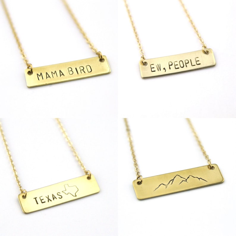K&ouml;nnte beinhalten: Vier goldene Halsketten mit verschiedenen rechteckigen Anh&auml;ngern. Die Anh&auml;nger zeigen den Text "Mama Bird", "Ew, People", "Texas" mit einer Umrandung des Bundesstaates und einem Bergketten-Design.