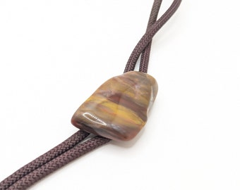 May include: A brown leather bolo tie with a large, irregularly shaped, multi-colored stone pendant.