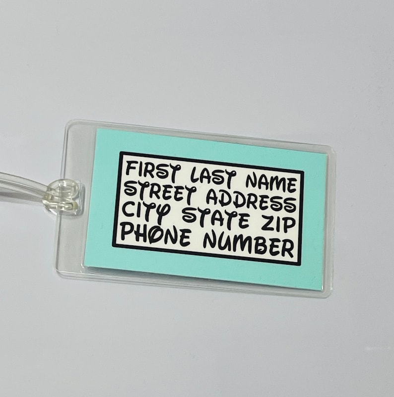 May include: A light blue luggage tag with a white background and black text. The text reads "First Last Name, Street Address, City State Zip, Phone Number".