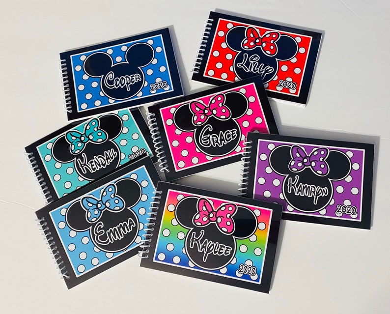 Pode incluir: Seis cadernos de espiral pretos com capas de bolinhas coloridas e uma imagem de desenho animado das orelhas do Mickey Mouse com um la&ccedil;o. Cada caderno tem um nome e o ano 2020 impresso na capa. Os nomes s&atilde;o Cooper, Kendall, Grace, Kamryn, Emma e Kailee.