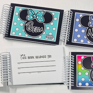 Op de afbeelding: Drie gepersonaliseerde Disney-thema spiraalnotitieblokken met een Mickey Mouse-personageontwerp. De omslagen hebben een blauw en wit stippenpatroon, een turquoise en wit stippenpatroon en een regenboog en wit stippenpatroon. De notitieblokken hebben de namen "Bella", "Nora" en "Mia" op de omslagen gedrukt, samen met het jaar "2022". De binnenkant van de notitieblokken heeft een blanco pagina met de tekst "Dit boek behoort toe aan:" en regels om een naam, straat, stad, provincie en postcode te schrijven.
