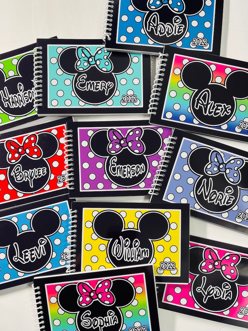 Pode incluir: Uma cole&ccedil;&atilde;o de cadernos personalizados coloridos com uma silhueta do Mickey Mouse com bolinhas e um la&ccedil;o. Cada caderno tem um nome diferente e o ano 2022 impresso na capa.