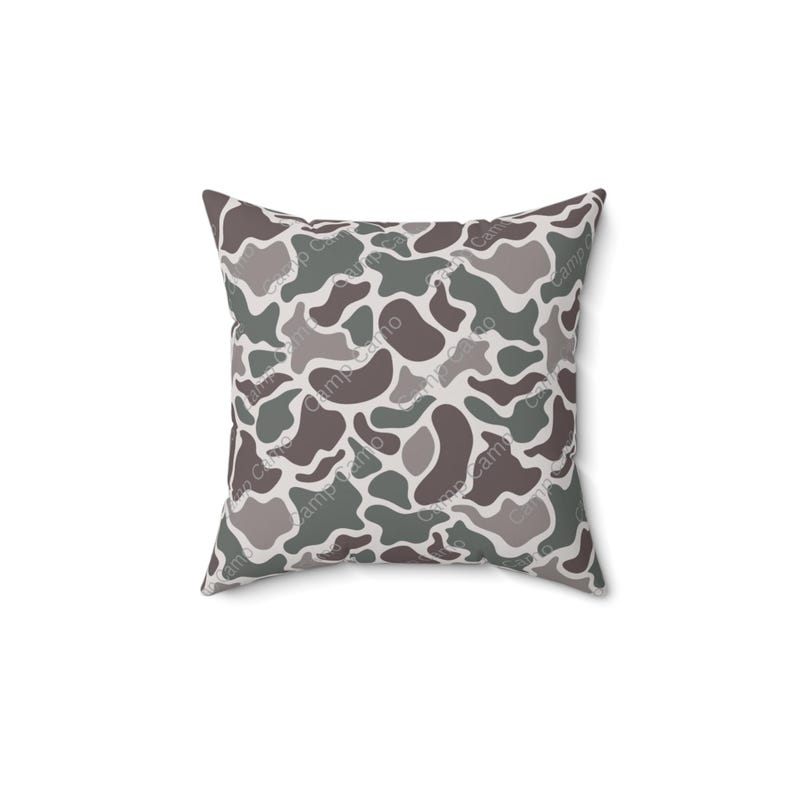 May include: A gray, green, and brown camouflage patterned throw pillow.