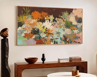 May include: A living room scene featuring a large, framed abstract painting with a floral theme in shades of orange, yellow, and green. A dark wood bench holds a wooden bowl, a black vase, and books. A white coffee table and a brown rug complete the decor.