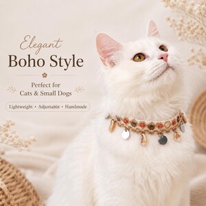 May include: A white cat wearing a handmade, adjustable, lightweight collar in an elegant boho style. The collar features shells, small red beads, and silver-colored charms. Text on the image reads "Elegant Boho Style" and "Perfect for Cats & Small Dogs."