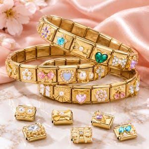 May include: Gold charm bracelets with decorative charms featuring hearts, bows, flowers, and gemstones. The bracelets are presented on a pink satin surface, highlighting the intricate details and design of the jewellery.