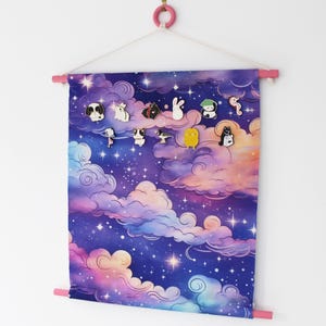 May include: A rectangular fabric wall hanging featuring a purple and blue night sky with swirling clouds and stars. The banner is suspended from a pink wooden rod and includes several small enamel pins of various animals attached to the fabric.
