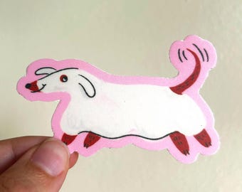 May include: A sticker of a cartoon dog in a running pose. The dog has a white body, pink outline, and red accents on its paws and tail. The sticker is held by a hand. The sticker is pink and white.