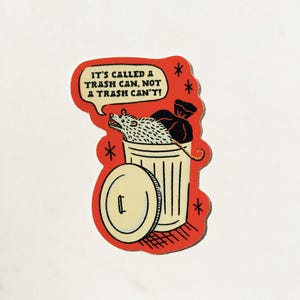 May include: A red and white sticker with a cartoon rat in a trash can. The sticker says "It's called a trash can, not a trash can't!"
