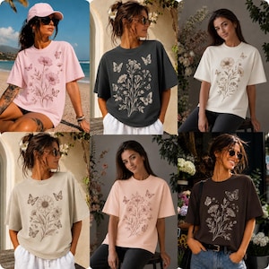 May include: A selection of six short-sleeved t-shirts in different colours, each with a floral and butterfly design. The shirts are in shades of pink, black, cream, beige, peach, and brown. The floral designs are in a contrasting colour to the shirt.