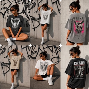 May include: A selection of oversized graphic t-shirts in different colours, each with angel-themed designs and text. The shirts display phrases such as "Dreamer", "Balance", "Rebel Soul", "Chaos", and "Rise Above". The designs are printed on the front and back.