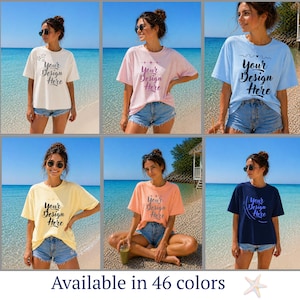 May include: A collection of six t-shirts in various colors, each featuring the text "Your Design Here." The shirts are displayed on a person wearing denim shorts, with a beach and ocean backdrop. The text "Available in 46 colors" is at the bottom.