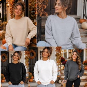 May include: A collection of five long-sleeved crewneck sweatshirts in solid colours including beige, light grey, black, white, and dark charcoal grey. Each sweatshirt features a ribbed neckline, cuffs, and hem, with a relaxed fit design.
