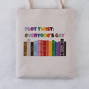 May include: A beige tote bag with a rainbow-coloured design that says "PLOT TWIST: EVERYONE'S GAY" and features a row of colourful books.