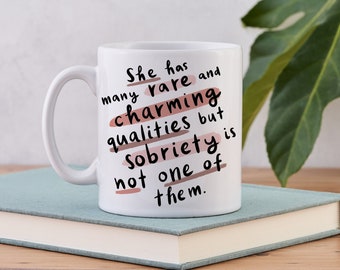 May include: White ceramic mug with a black and pink design. The mug has a quote that reads "She has many rare and charming qualities but sobriety is not one of them."