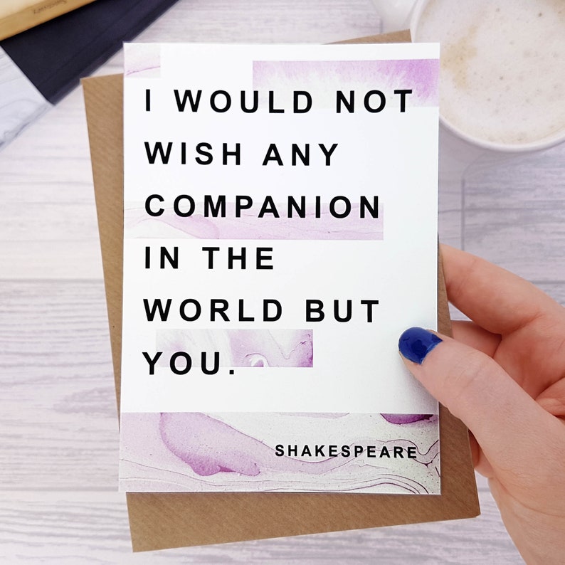 May include: A white card with a purple watercolour background. The card has a quote in black text that reads "I would not wish any companion in the world but you." The quote is attributed to Shakespeare.