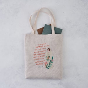 May include: A beige tote bag with a quote from Jane Austen's novel Pride and Prejudice printed on it. The quote reads, "It will make the surprise the greater when I write to them and sign my name 'Lydia Wickham'. What a good joke it will be! I can hardly write for laughing."