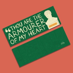 以下が含まれることがあります： 白い文字で「Thou art the armouerer of my heart」と書かれた緑色のしおり。しおりには、男性の胸像と、その下に「Mark Antony」という文字が書かれています。
