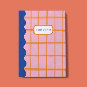 May include: A pink and orange chequered notebook with a blue scalloped edge. The notebook has a white label with the text "A NEW CHAPTER" in blue.