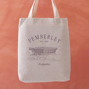 May include: A beige tote bag with cream-colored handles. The bag features the word "PEMBERLEY" above an illustration of a stately building, with "EST. 1813" below it. The word "Derbyshire" is printed at the bottom.