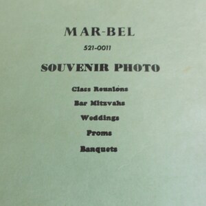 May include: A green paper flyer with the text "MAR-BEL 521-0011 SOUVENIR PHOTO" and a list of events: Class Reunions, Bar Mitzvahs, Weddings, Proms, Banquets.